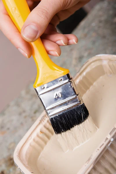 Gele penseel in werknemer hand — Stockfoto