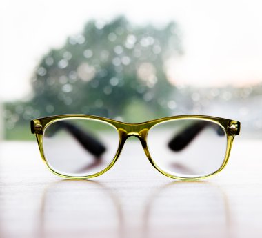 Okuma gözlüğü yağmurlu pencere arka plan üzerinde