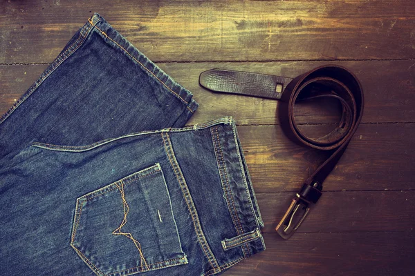 Jeans met riem op houten achtergrond — Stockfoto