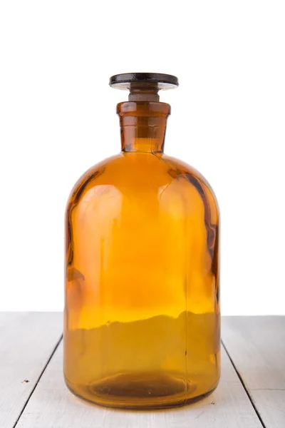 Vintage medicin flaska på träbord isolerad på vit — Stockfoto