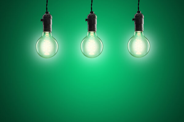 Idea concept - Vintage incandescent bulbs on green background