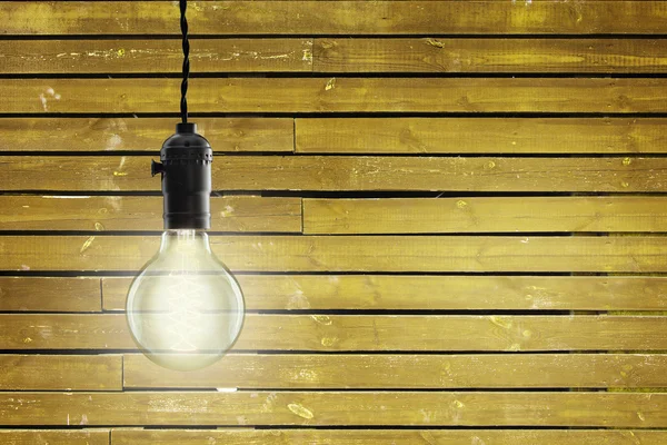 Vintage incandescent Edison type bulb on wooden background — Stock Photo, Image