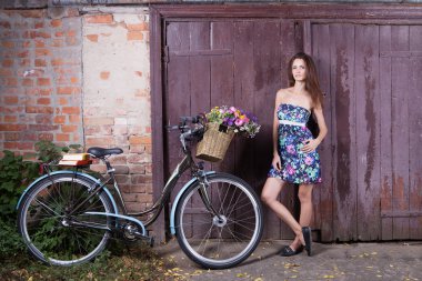 Vintage bir bisiklet ve bir sepet çiçek ile kız