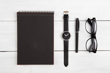 Not Defteri, saatler, kalem ve Okuma gözlükleri masanın üstüne