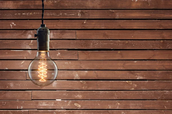 Vintage incandescent Edison type bulb on wooden background — Stock Photo, Image