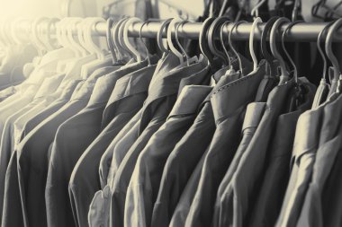 Giysiler tasarımcı giyim mağazasının rafında asılı.