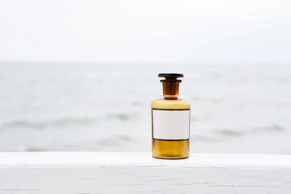 Vintage geneeskunde fles op zee achtergrond — Stockfoto