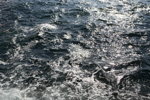 Olas y salpicaduras en la superficie del agua — Foto de Stock