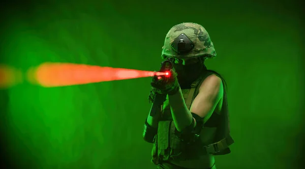 Donna in uniforme militare con fucile automatico americano in casco e passamontagna su sfondo verde — Foto Stock