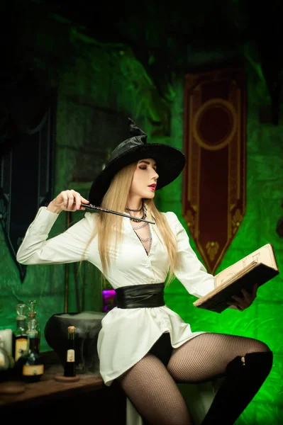 Mulheres em um chapéu na sala de bruxas no Halloween — Fotografia de Stock