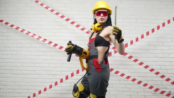 Femme sexy en salopette et un casque de construction changer foret bit dans la perceuse — Video