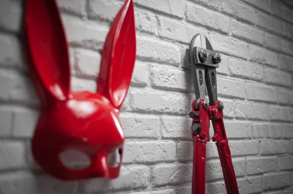 Kreativní návrh žáruvzdorné cihlové stěny s Bunnyho maskou a šroubovými štípačkami s těsným řetězem — Stock fotografie