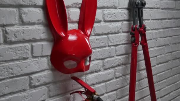 Kreativní návrh protipožární cihlové stěny s králičí maskou, hasicími přístroji a šrouby s nataženým řetězem — Stock video