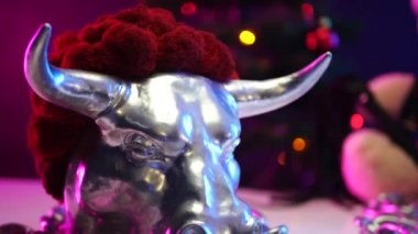 Noel günü Noel Baba şapkası takan oyuncak ayı, metal boğa yılında zincirlenir.