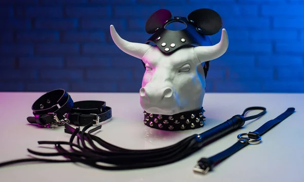 Beeldje van een witte metalen stier in een leren masker en accessoires voor BDSM spellen — Stockfoto