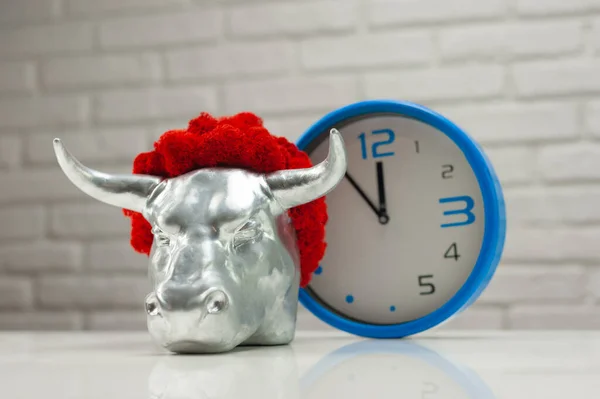 Statuetta di un toro in metallo bianco simbolo del nuovo anno 2021 accanto all'orologio — Foto Stock