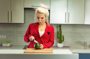 Sarışın vejetaryen kadın mutfakta avokado kesti.