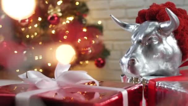 Wit metalen stier symbool van 2021 op de achtergrond van een kerstboom en verlichting, — Stockvideo