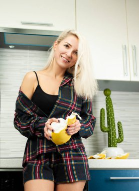 Mutfakta kadın, ev kıyafetleri içinde meyve püresini duygularıyla temizliyor.