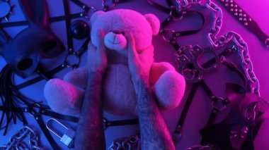 Eller masadaki oyuncak ayıya dokunur BDSM aksesuar zincir kırbaç zinciri ile neon ışıklı oyunlar için maske takar