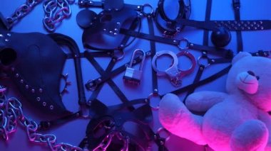 Deri kemer takmış oyuncak ayı BDSM oyunları için aksesuar dumandaki neon ışıkta karanlık bir arka planda