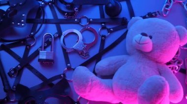 Deri kemer takmış oyuncak ayı BDSM oyunları için aksesuar dumandaki neon ışıkta karanlık bir arka planda