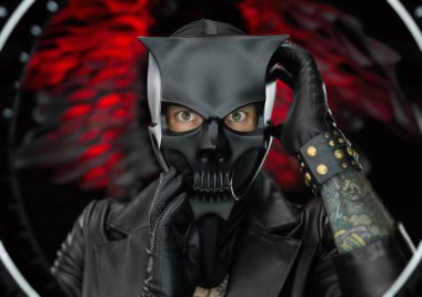 Deri pelerinli şeytan kafatası maskesi takan bir adam.