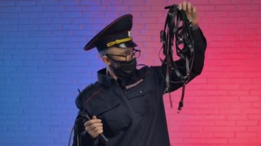 Coronavirus maskesi takan polis üniformalı bir adam deri kemerlere ve BDSM 'e şaşkınlıkla bakıyor. İngilizce çeviri Polis, Rusya