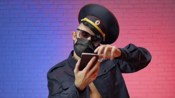 Een man in een Russisch militair politie-uniform met een coronavirus masker telt de steekpenningen en geeft de documenten terug. Engelse vertaling Politie, Rusland — Stockvideo