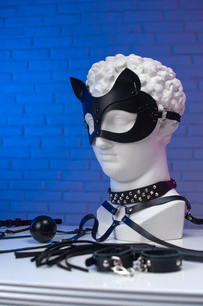 Plaster head of David in accessories BDSM mask whip leather collar and belt