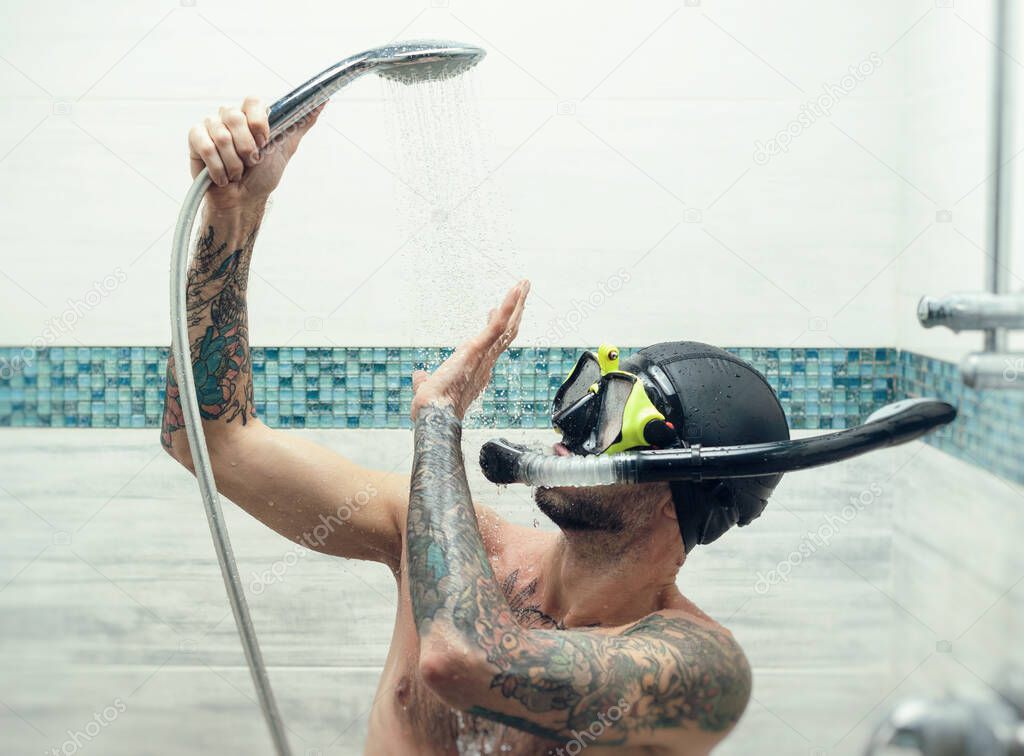a man wearing a scuba mask in the shower is doused with water
