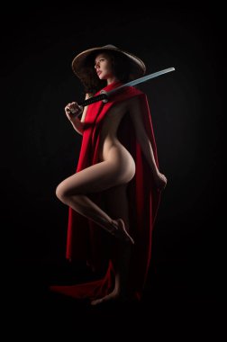 Kırmızı pelerinli çıplak bir kadın ve elinde bir katana olan Asyalı bir şapkalı bir samuray.