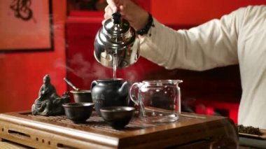 Geleneksel Çin geleneklerine göre PU-erh çayı yapan bir adam.