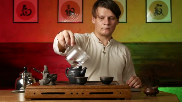 En man brygger PU-erh te enligt traditionell kinesisk tull — Stockvideo