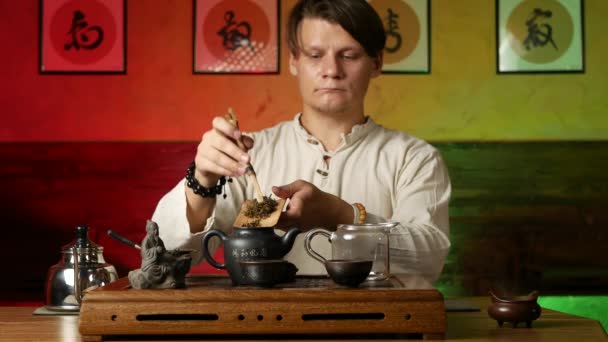 Un hombre prepara té PU-erh según las costumbres chinas tradicionales — Vídeo de stock