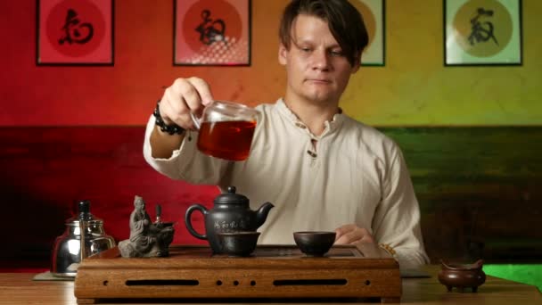 Een man zet PU-erh thee volgens de traditionele Chinese gebruiken — Stockvideo