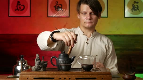 Человек варит чай ПУ-эрх в соответствии с традиционными китайскими обычаями — стоковое видео
