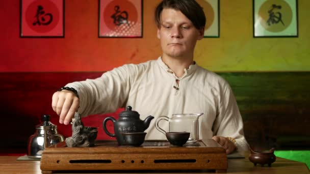 Un hombre prepara té PU-erh según las costumbres chinas tradicionales — Vídeo de stock