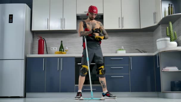 A guy who works for a cleaning company, cleans the kitchen floor and dances — Stock Video