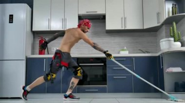 a guy who works for a cleaning company, cleans the kitchen floor and dances