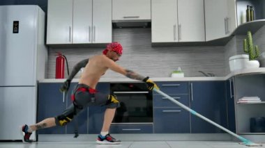 a guy who works for a cleaning company, cleans the kitchen floor and dances