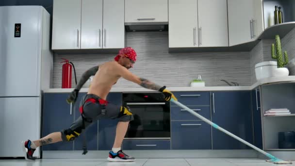 Un gars qui travaille pour une entreprise de nettoyage, nettoie la cuisine et danse — Video