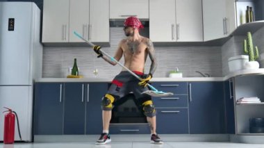 a guy who works for a cleaning company, cleans the kitchen floor and plays the mop like a guitar