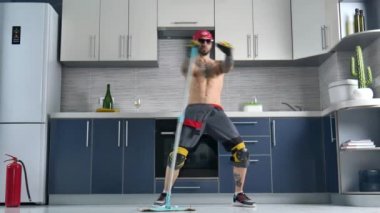 a guy who works for a cleaning company, cleans the kitchen floor and dances