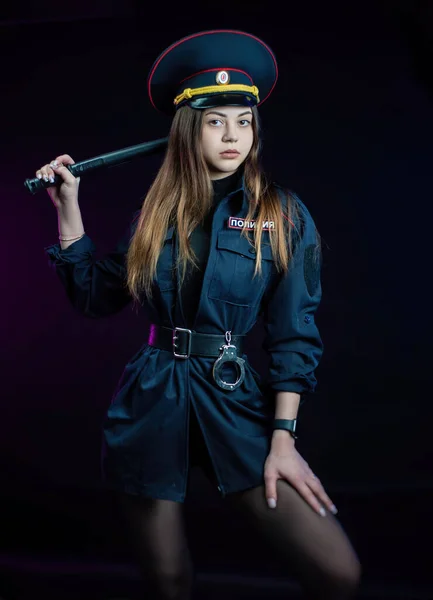 A woman in a Russian police uniform with a baton. English translation Police — Stock Photo, Image