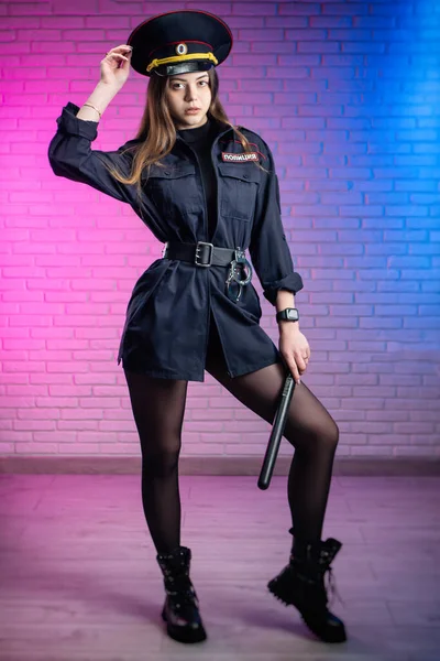 A woman in a Russian police uniform with a baton. English translation Police — Stock Photo, Image