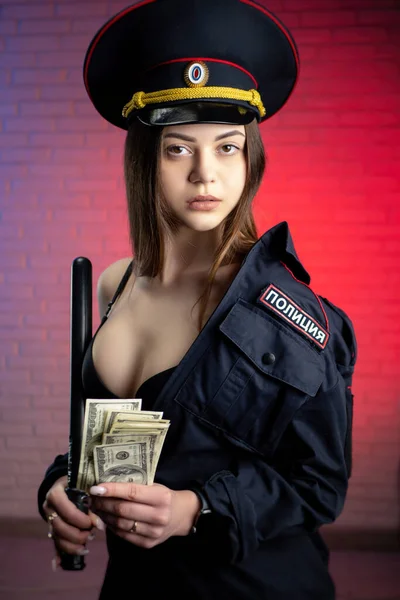 Sexy žena v ruské policejní uniformě s obuškem a penězi. Anglický překlad Policie — Stock fotografie