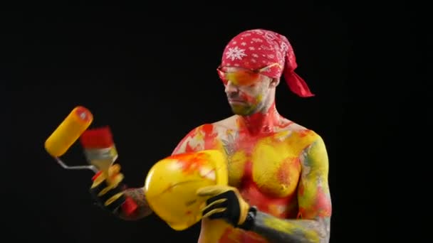 The man is a painter plasterer in a helmet and overalls painted with bright paint — Stock Video