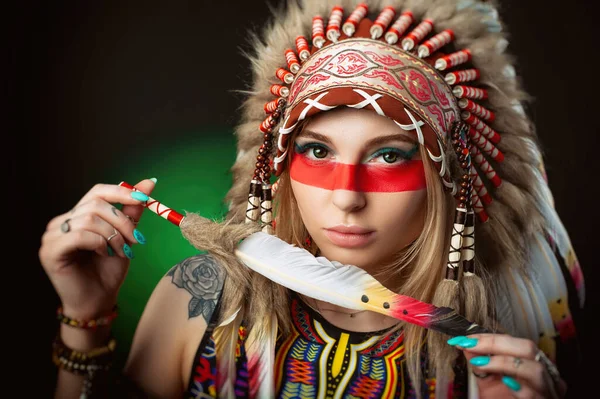 Retrato de uma mulher na imagem de um índio americano em uma capa de barata com uma caneta em suas mãos — Fotografia de Stock