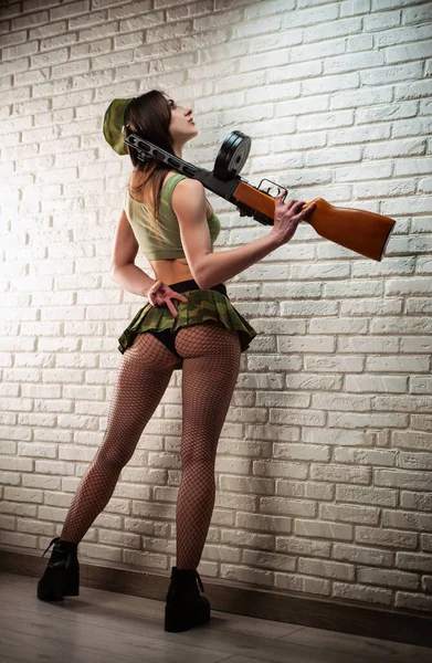 Kobieta w seksownym sowieckim mundurze wojskowym z pistoletem maszynowym PPSh-41 w krótkiej spódnicy i skórzanych paskach, mundur II Wojny Światowej Związku Radzieckiego — Zdjęcie stockowe